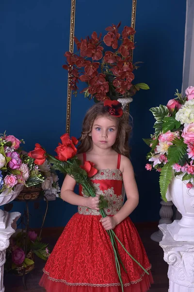 彼女の手と彼女の周りの花で赤いドレスを着たプリンセス少女の肖像画 — ストック写真