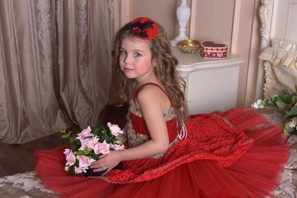 Egy Kis Lány Hercegnő Egy Piros Ruhát Kalapot Portréja Kanapén — Stock Fotó