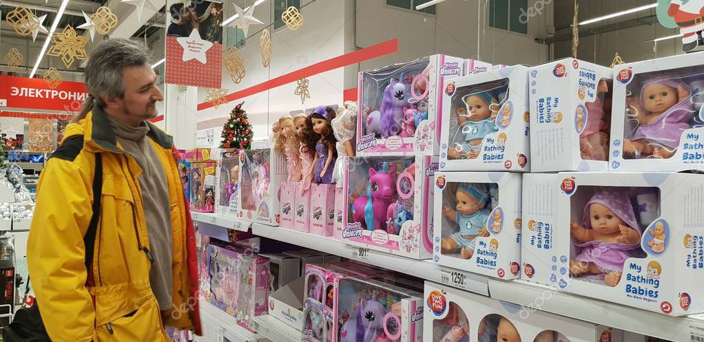 Russia, St. Petersburg, 12,12,2018 A man chooses gifts for children in the department of toys, dolls  in the supermarket