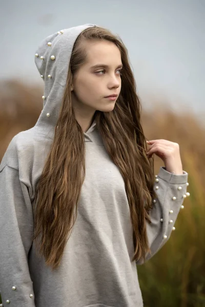 Bir Kukuleta Ile Gri Süveterli Uzun Kahverengi Saçlı Genç Kız — Stok fotoğraf