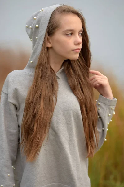 Bir Kukuleta Ile Gri Süveterli Uzun Kahverengi Saçlı Genç Kız — Stok fotoğraf