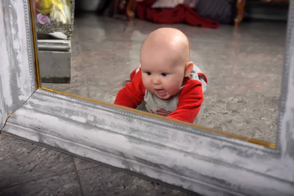 Милый Новорожденный Ребенок Красном Серой Одеждой Перед Зеркалом Смотрит Себя — стоковое фото