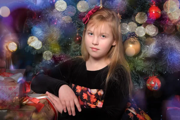 女孩金发碧眼的孩子在黑色与红色礼服在圣诞节独自的圣诞树 — 图库照片