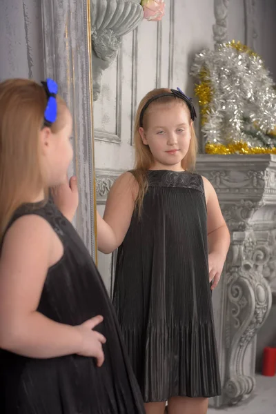 Siyah Elbiseli Kız Sarışın Çocuk Kendini Aynaya Bakar — Stok fotoğraf