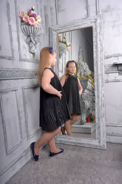 Fille Blonde Enfant Dans Une Robe Noire Regarde Dans Miroir — Photo