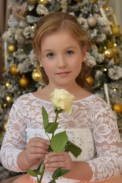 在圣诞节 穿着别致的白色桃子礼服 手里拿着一朵白玫瑰 金发碧眼 — 图库照片