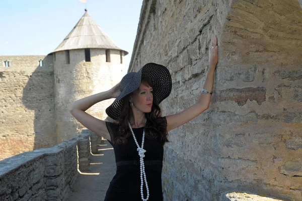 Mulher Vestido Preto Chapéu Fundo Uma Fortaleza Medieval — Fotografia de Stock