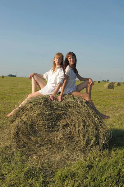 干し草の山の野原で白いシャツを着た2人の女性 — ストック写真