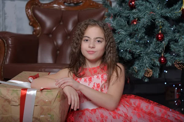 ホワイト クリスマスに贈り物をクリスマス ツリーに赤いドレスの女の子 — ストック写真
