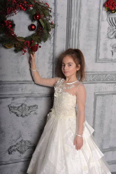 Dziewczyna Białej Sukni Obok Boże Narodzenie Wieniec Drzwi — Zdjęcie stockowe