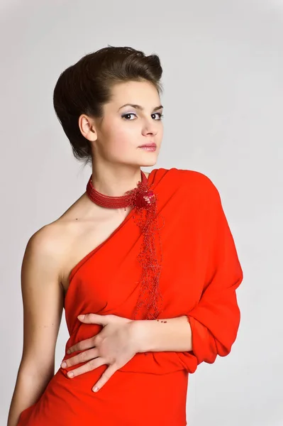 ホワイト スタジオの背景に彼女の首にネックレスの赤の美しい若いブルネット — ストック写真