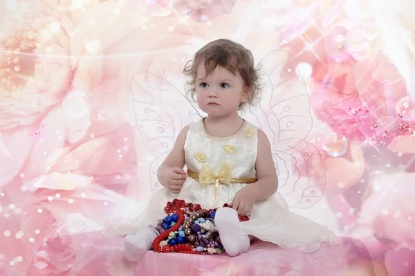 白いドレスの蝶の羽と座っている小さな少女の肖像画 — ストック写真