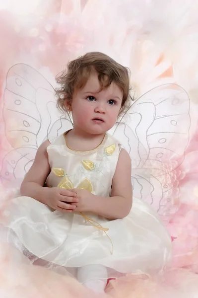 小女孩肖像坐在蝴蝶翅膀在白色礼服 — 图库照片