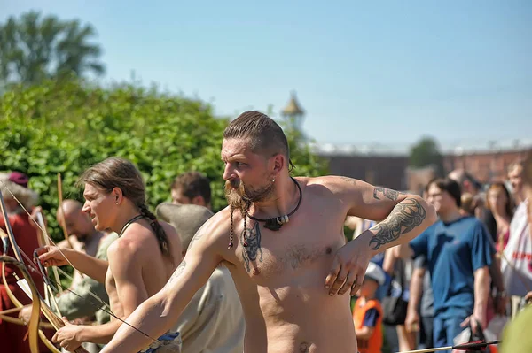 Menschen in mittelalterlichen Gewändern schießen aus einem Bogen beim Fest der h — Stockfoto