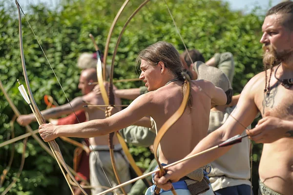 Menschen in mittelalterlichen Gewändern schießen aus einem Bogen beim Fest der h — Stockfoto