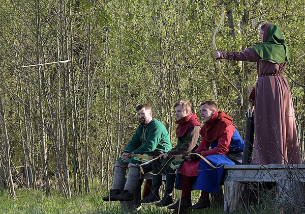 People in medieval clothes shoot from a bow at the festival of h — Stock Photo, Image