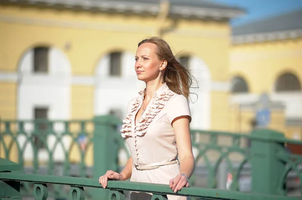 Ung kvinna i beige klänning på bron — Stockfoto