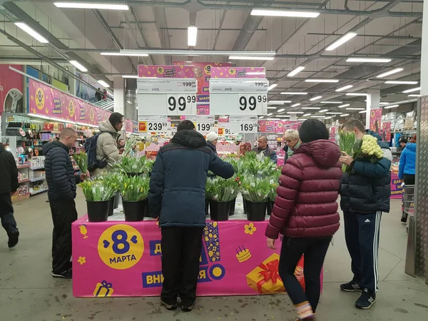 La gente compra flores en el supermercado de vacaciones. — Foto de Stock