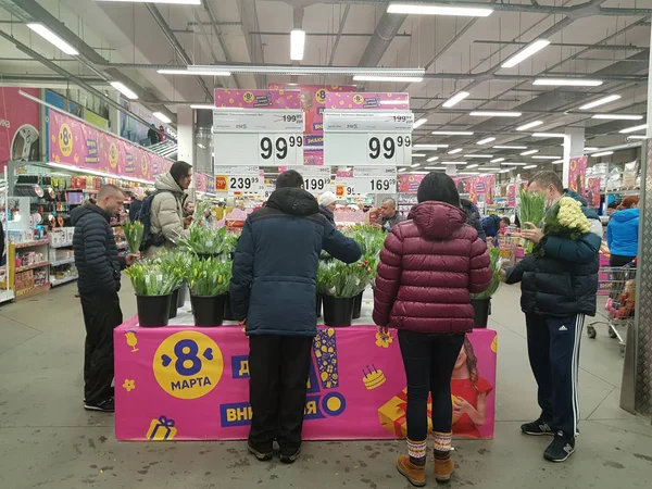 Люди купують квіти в супермаркеті на свято — стокове фото