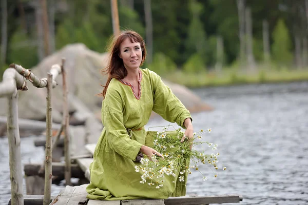 Woman by the water with a wreath in her hands — Stok fotoğraf