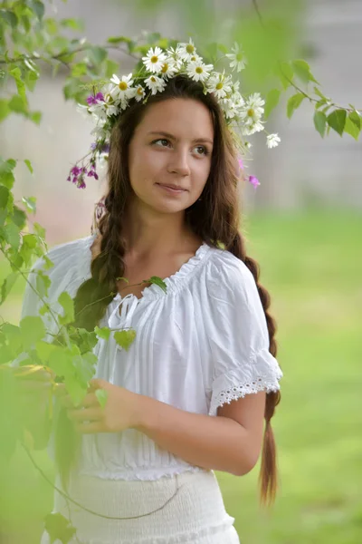 Sweet Russian girl girl in a white birch in the summer, with a w — Stock Photo, Image