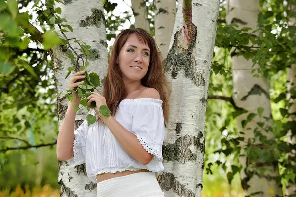 Woman in white by birch in summer — Stok fotoğraf