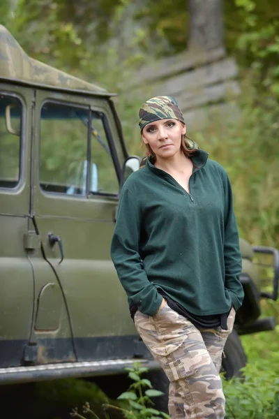 Mujer con bandana de camuflaje en el telón de fondo de UAZ . — Foto de Stock