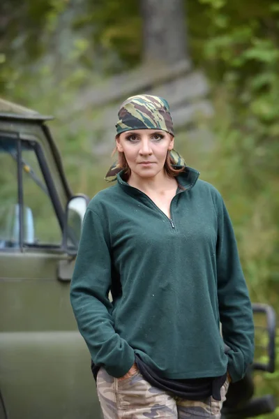 Vrouw het dragen van camouflage Bandana tegen de achtergrond van UAZ. — Stockfoto