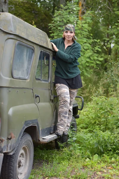 Donna che indossa bandana mimetica sullo sfondo di UAZ . — Foto Stock