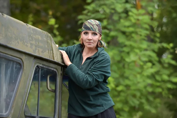 Woman wearing camouflage bandana against the backdrop of UAZ. — Stock Photo, Image