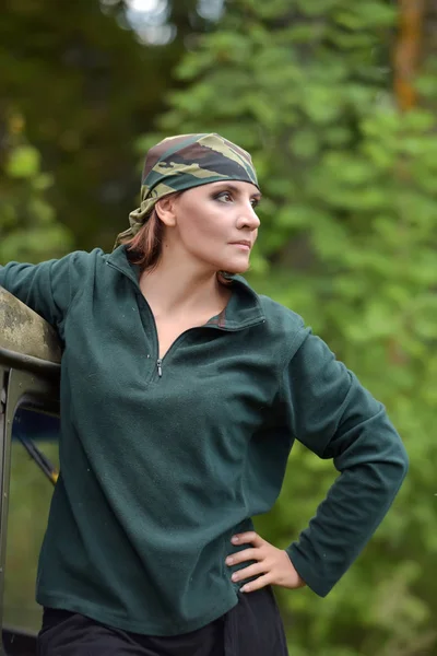 Femme portant un bandana de camouflage sur fond d'UAZ . — Photo