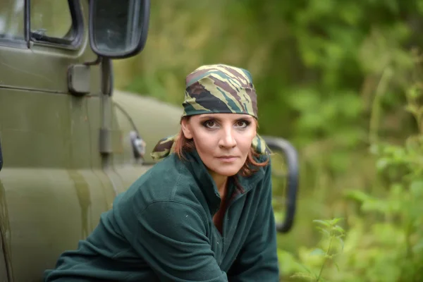 Woman wearing camouflage bandana against the backdrop of UAZ. — Stock Photo, Image