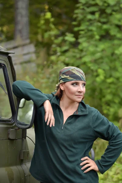 Vrouw het dragen van camouflage Bandana tegen de achtergrond van UAZ. — Stockfoto