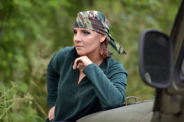 Vrouw het dragen van camouflage Bandana tegen de achtergrond van UAZ. — Stockfoto