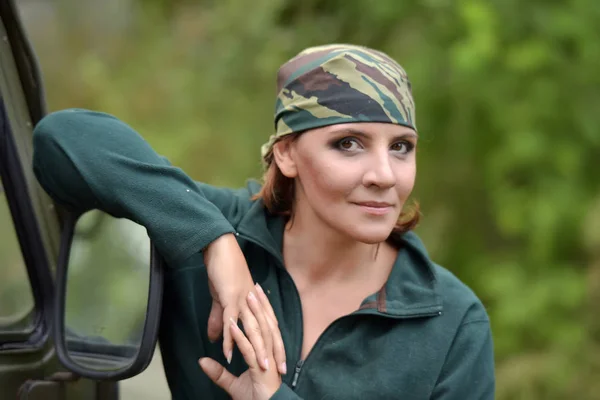 Woman wearing camouflage bandana against the backdrop of UAZ. — Stock Photo, Image