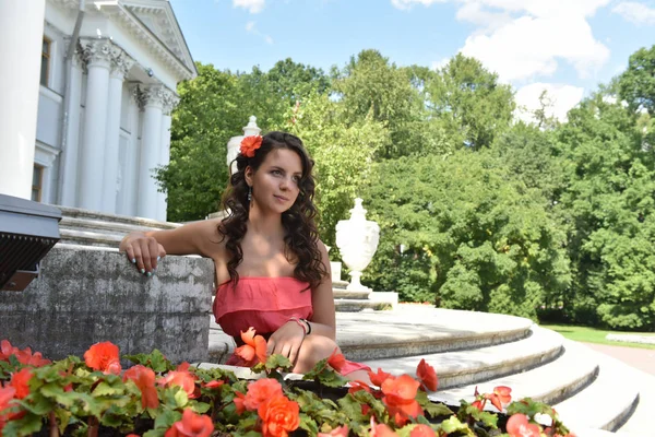 Schöne Brünette mit lockigem Haar und einem rosa Kleid in der Summe — Stockfoto