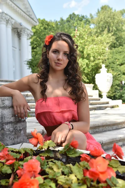 Hermosa morena con el pelo rizado y un vestido rosa en la summe — Foto de Stock