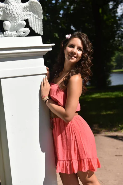 Bella bruna con i capelli ricci e abito rosa all'aperto — Foto Stock