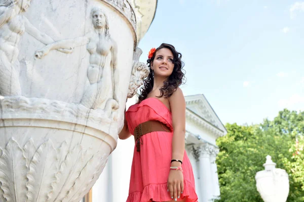 Schöne Brünette mit lockigem Haar und rosa Kleid im Freien — Stockfoto