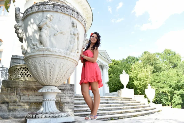 Hermosa morena con pelo rizado y vestido rosa al aire libre — Foto de Stock