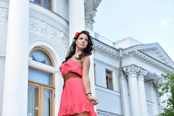Hermosa morena con pelo rizado y vestido rosa al aire libre — Foto de Stock