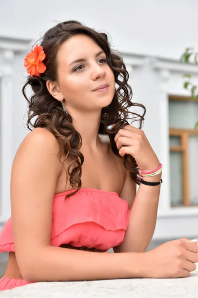 Beautiful brunette with curly hair and pink dress outdoor — Stock Photo, Image