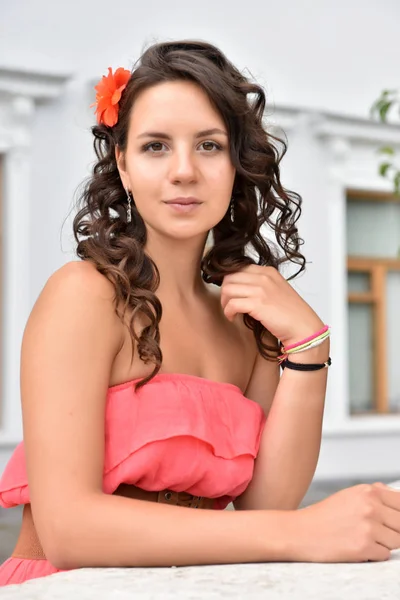 Krásná bruneta se kudrnatými vlasy a růžovými šaty venku — Stock fotografie
