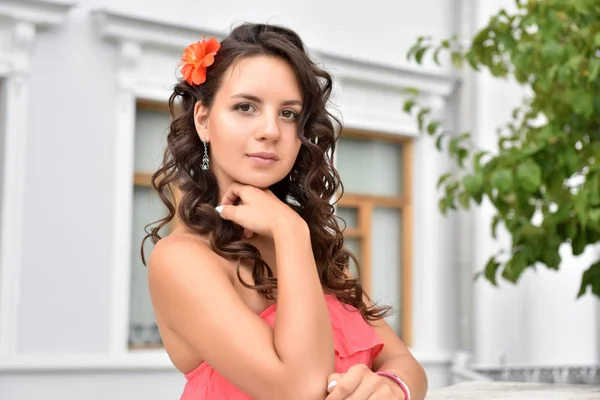 Hermosa morena con pelo rizado y vestido rosa al aire libre — Foto de Stock