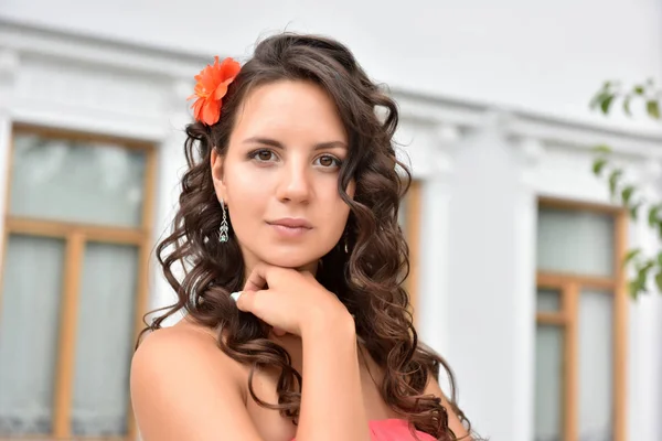 Krásná bruneta se kudrnatými vlasy a růžovými šaty venku — Stock fotografie