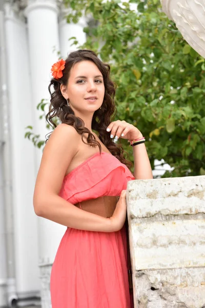 Hermosa morena con pelo rizado y vestido rosa al aire libre — Foto de Stock