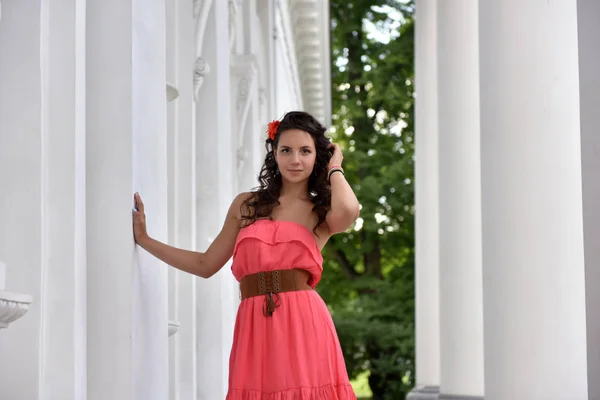 Carino bruna con i capelli ricci in un abito rosa — Foto Stock