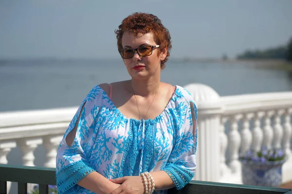 Red-haired woman in summer with a short haircut and sunglasses i — Stock Photo, Image