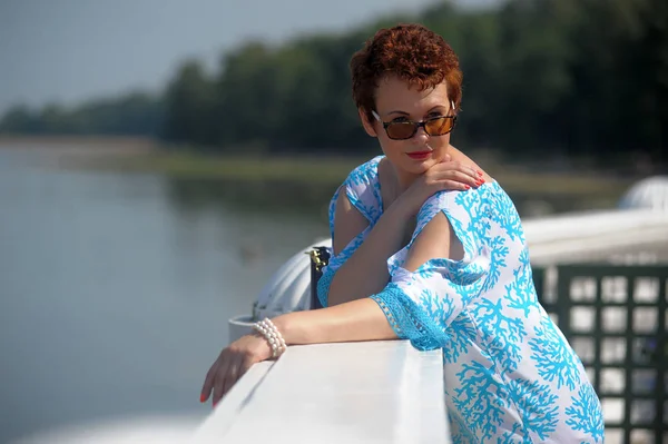 Κοκκινομάλλα γυναίκα το καλοκαίρι με ένα σύντομο κούρεμα και γυαλιά ηλίου — Φωτογραφία Αρχείου