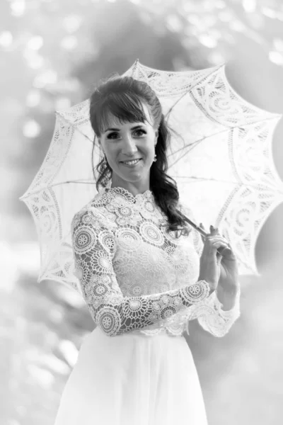 Elegante morena en un vestido blanco vintage con paraguas en th —  Fotos de Stock